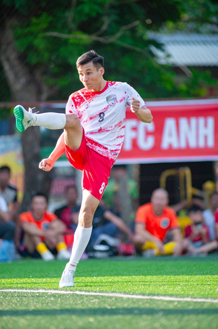 Services Soccer player performing a high kick on outdoor field, vibrant action shot.