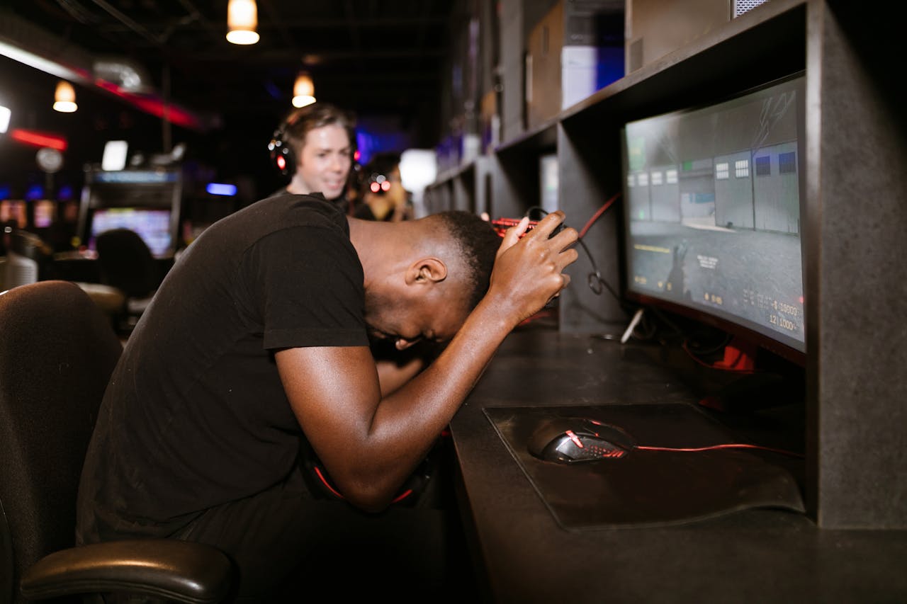 About An adult male gamer shows frustration while playing a computer game in an esports arena.